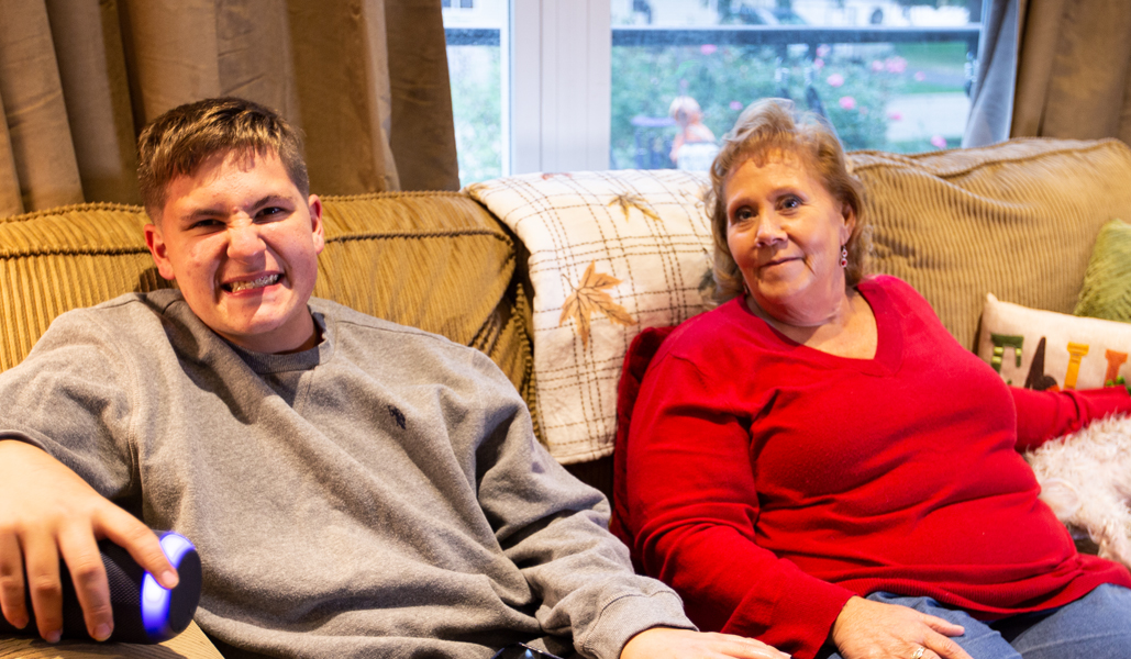 Two people sitting together on a living-room couch.